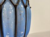 a blue glass vase sitting on a table with a black handle