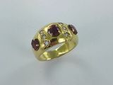 gros plan d'une bague en or avec une pierre rouge