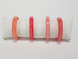 three red and white bracelets are stacked on top of each other