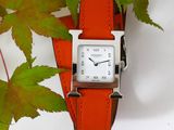 a watch that is sitting next to a plant