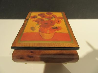 une petite boîte en bois décorée d'une peinture représentant des fleurs