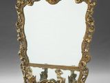 an ornately decorated mirror stands on a stand with a mirror in the middle of it