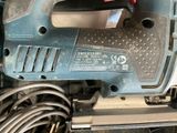 someone is using a corded jig saw to cut a piece of wood