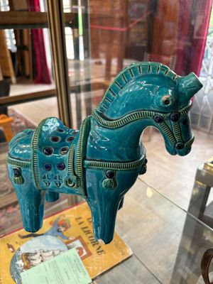 une figurine de cheval bleu exposée dans une vitrine