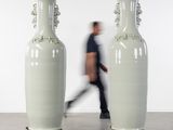 deux grands vases blancs posés sur des roulettes dans une pièce