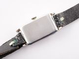 a watch that is sitting on a black leather strap