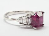 un gros plan d'une bague sertie d'un rubis et de diamants sur fond blanc
