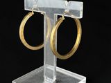 présentoir à bijoux en acrylique transparent avec deux boucles d'oreilles en forme d'anneau dorées