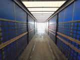 a long hallway with blue walls and wooden benches