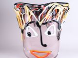 un vase en verre sur lequel est peint un visage