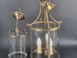 an image of two brass and glass lanterns on a grey background