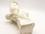 a statue of a woman laying down on a white surface