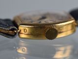 a close up of a gold watch with a black strap