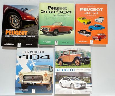 plusieurs livres posés sur une table, avec une voiture et une autre voiture devant eux