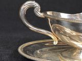 a silver cup and saucer on a saucer on a black table