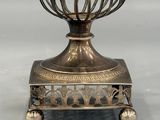 an image of a silver vase with a bird in it