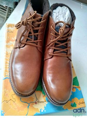 une paire de chaussures marron posée sur une carte