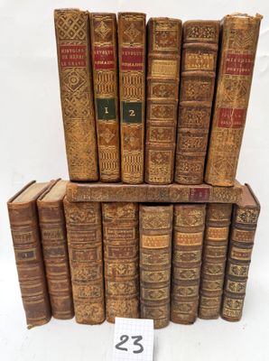 several old books stacked on top of each other on a white surface
