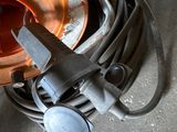 a large copper pot sitting on the floor with a hose attached to it