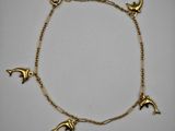 un bracelet en or orné de dauphins et d'étoiles
