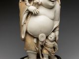 an ivory figurine of a laughing man holding a child