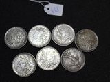 six silver coins with a price tag on a black surface