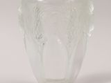 clear glass vase with two handles on a white surface