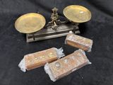 three antique brass scales and two wooden boxes on a black background