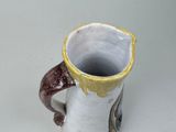 a white and brown cup with a handle on a table
