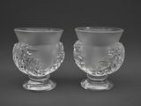 une paire de vases en verre transparent posés sur des socles, sur fond noir