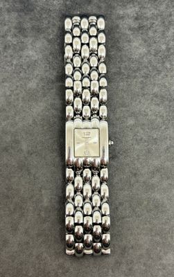 un gros plan d'une montre-bracelet posée sur une surface grise
