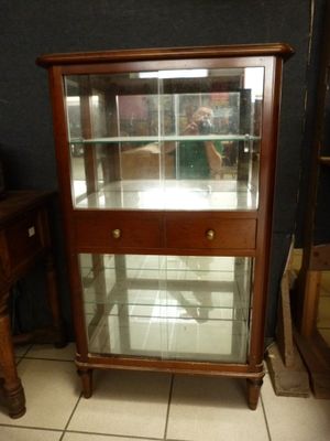 a display case with glass doors in the corner of a room