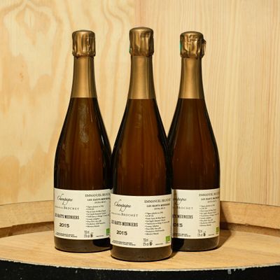 three bottles of wine sitting on top of a wooden barrel