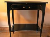 une petite table noire surmontée d'un tiroir