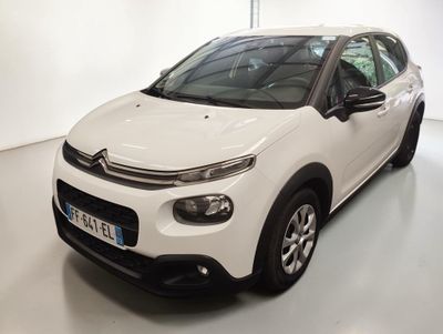 Une Citroën blanche est garée dans une pièce blanche