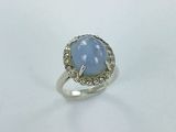 an image of a ring with a blue stone surrounded by diamonds