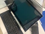 une table en verre sur laquelle sont posés un ordinateur portable et un clavier