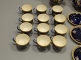a lot of blue and gold plates and cups on the table