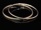 a close up of two silver rings on a black surface