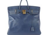 a blue leather handbag with a gold lock on the handle