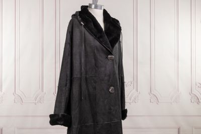 black leather coat with fur collar and cuffs on mannequin stand