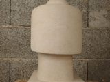 a white vase sitting on a table in front of a brick wall
