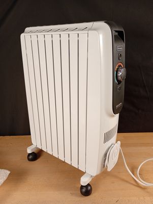 un radiateur électrique blanc posé sur une table en bois
