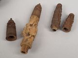 four pieces of carved wood sit on a table next to a knife
