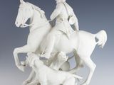 a figurine of a man riding on a horse with a dog