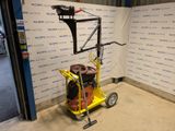 a yellow cart with a hose on it in front of a wall
