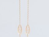 a long necklace hanging from the side of a white wall