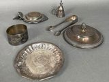 a silver plate with silverware on it and silver spoons
