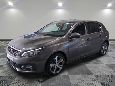 the grey car is parked on a checkered floor in the garage