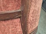 a close up of a wooden chair with a red upholstered seat